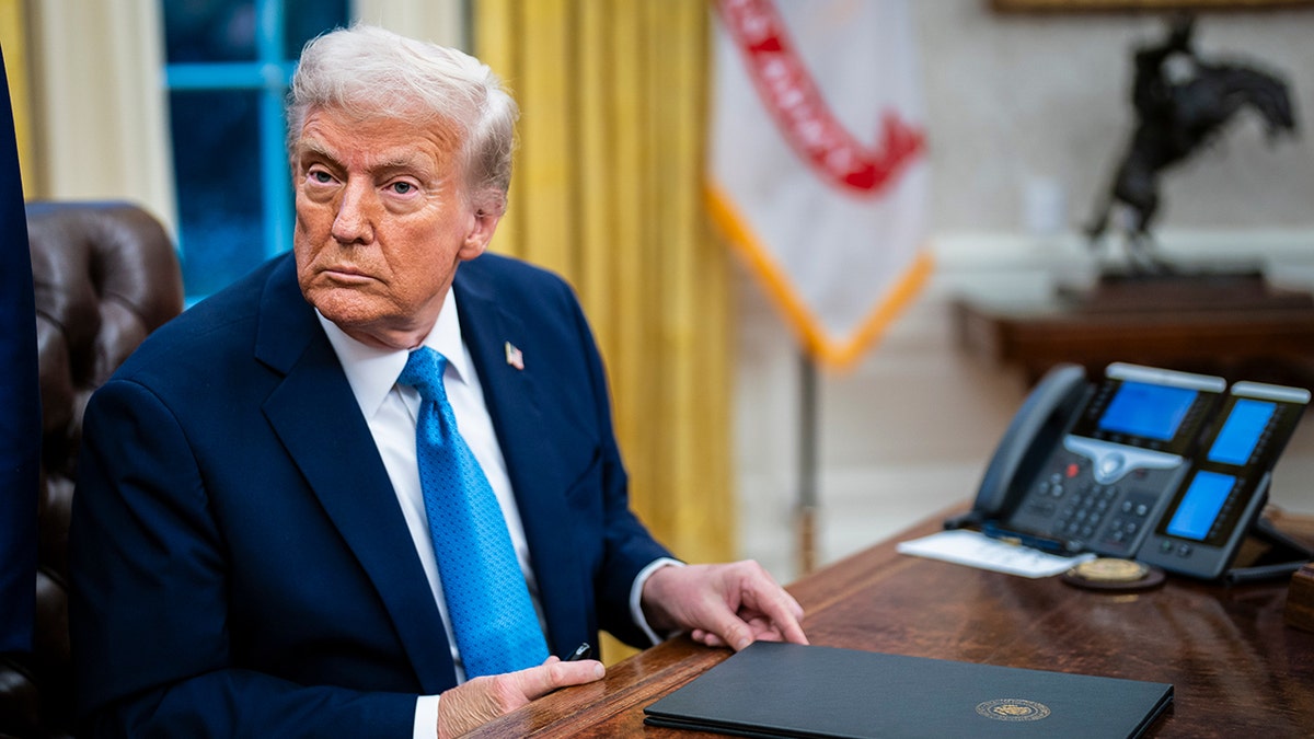 Trump at Resolute desk with document