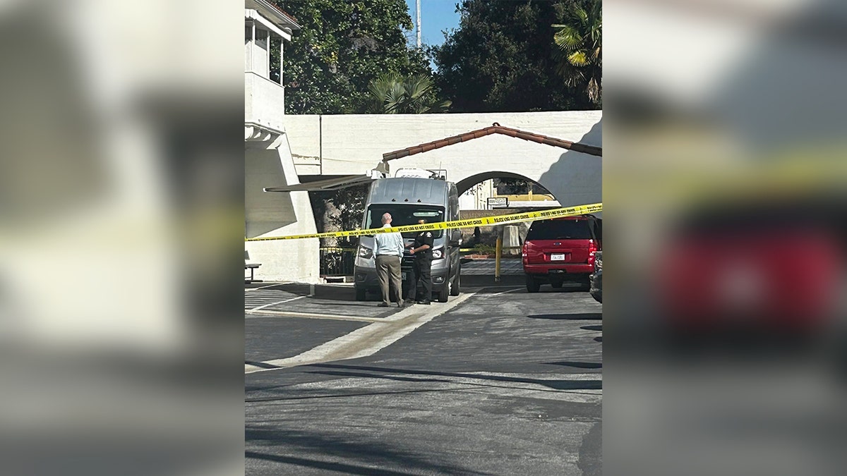 yellow tape surrounds building as officials look around