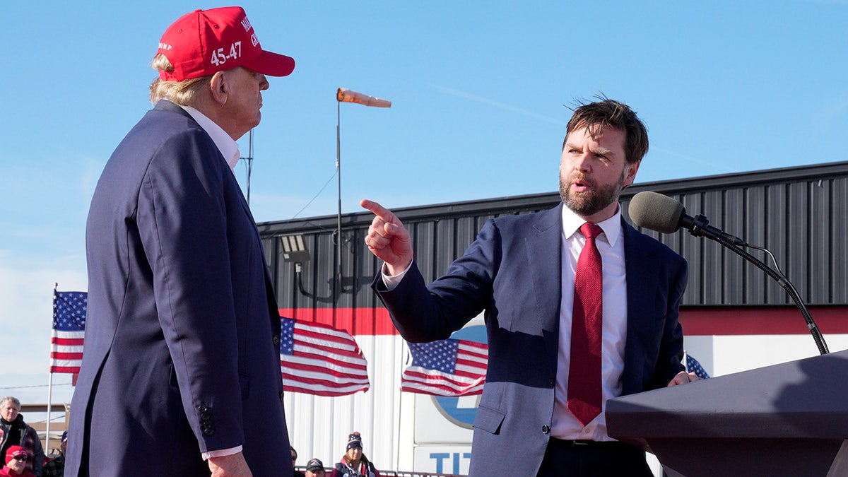 JD Vance points toward Republican presidential candidate former President Donald Trump