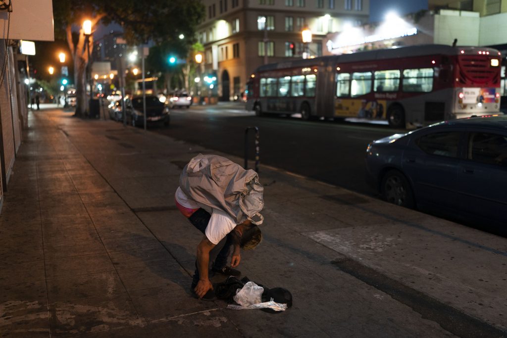 Anthony Delio, 36, falls asleep on a sidewalk after smoking fentanyl in Los Angeles, Tuesday, Aug. 23, 2022. 