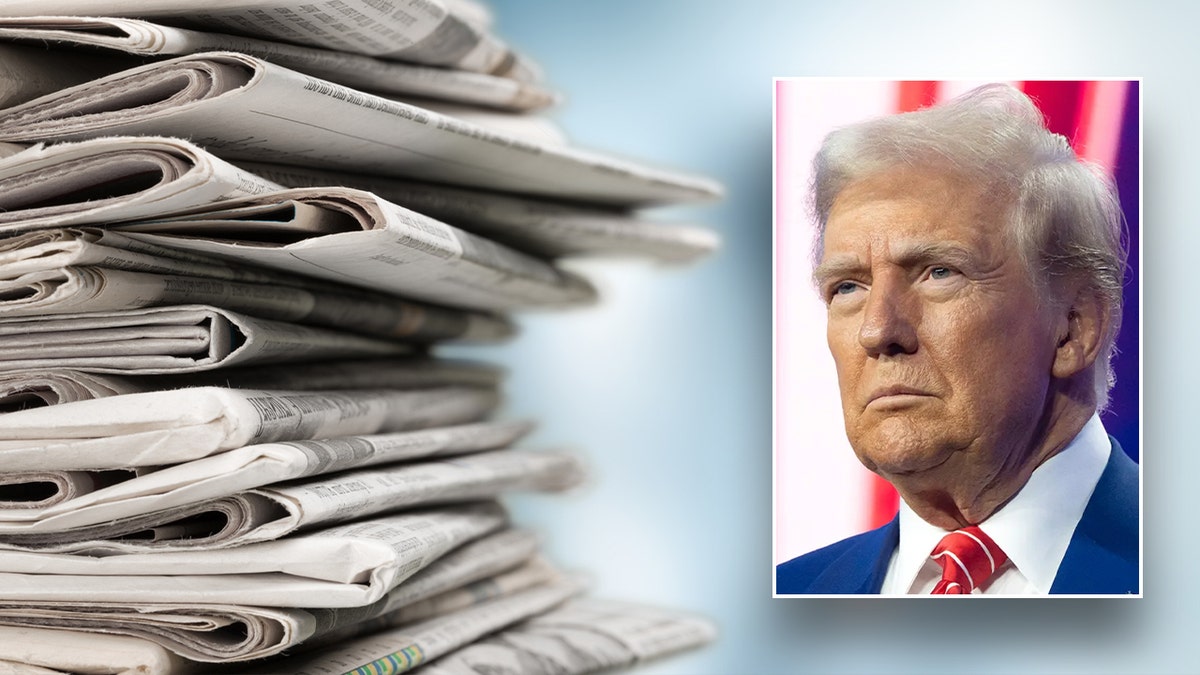 Donald Trump is pictured in front of newspapers.