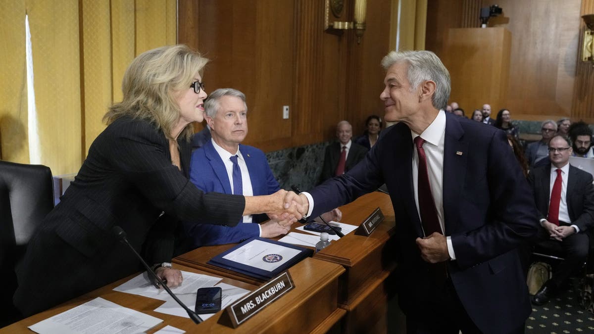 Dr. Mehmet Oz, President Donald Trump's pick to lead the Centers for Medicare and Medicaid Services, right, greets Sen. Marsha Blackburn, R-Tenn., as Sen. Roger Marshall, R-Kan., looks on before Oz testifies at his confirmation hearing before the Senate Finance Committee, on Capitol Hill in Washington, Friday, March 14, 2025. 