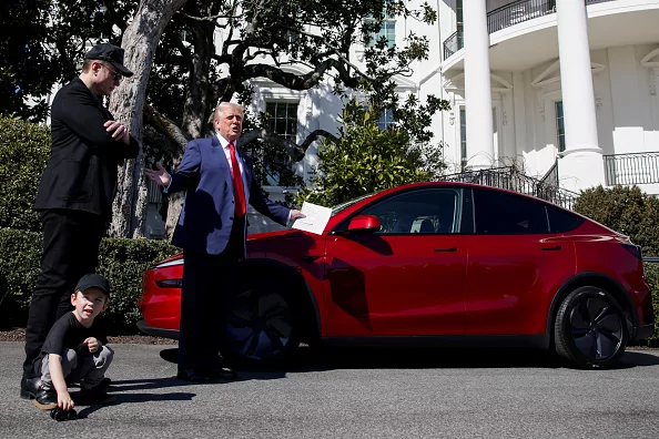 Elon Musk, chief executive officer of Tesla Inc., left, and US President Donald Trump speak to members of the media while looking at a Tesla Model S vehicle on the South Lawn of the White House in Washington, DC, US, on Tuesday, March 11, 2025. Trump said he'll buy a new Tesla to support Elon Musk, after shares of the electric-car maker had their worst day in four years amid a growing backlash over Musk's political allegiances.