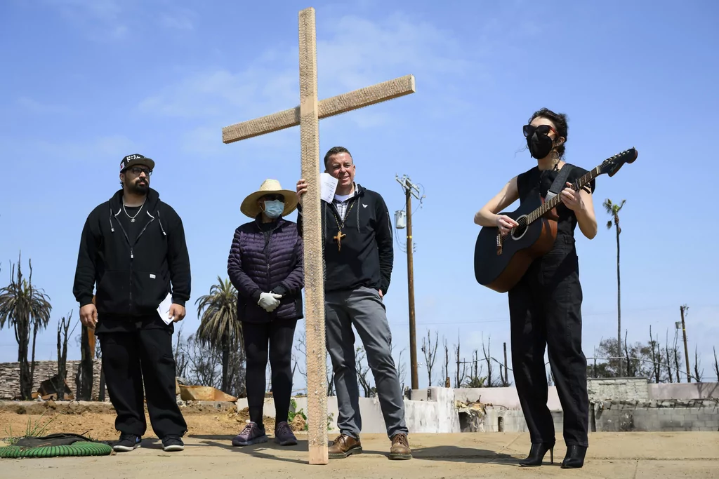 Carli Wright, right, plays music for a church prayer during a Cross Walk event by the Community United Methodist Church of the Pacific Palisades, Friday, April 18, 2025, in the Pacific Palisades area of Los Angeles.
