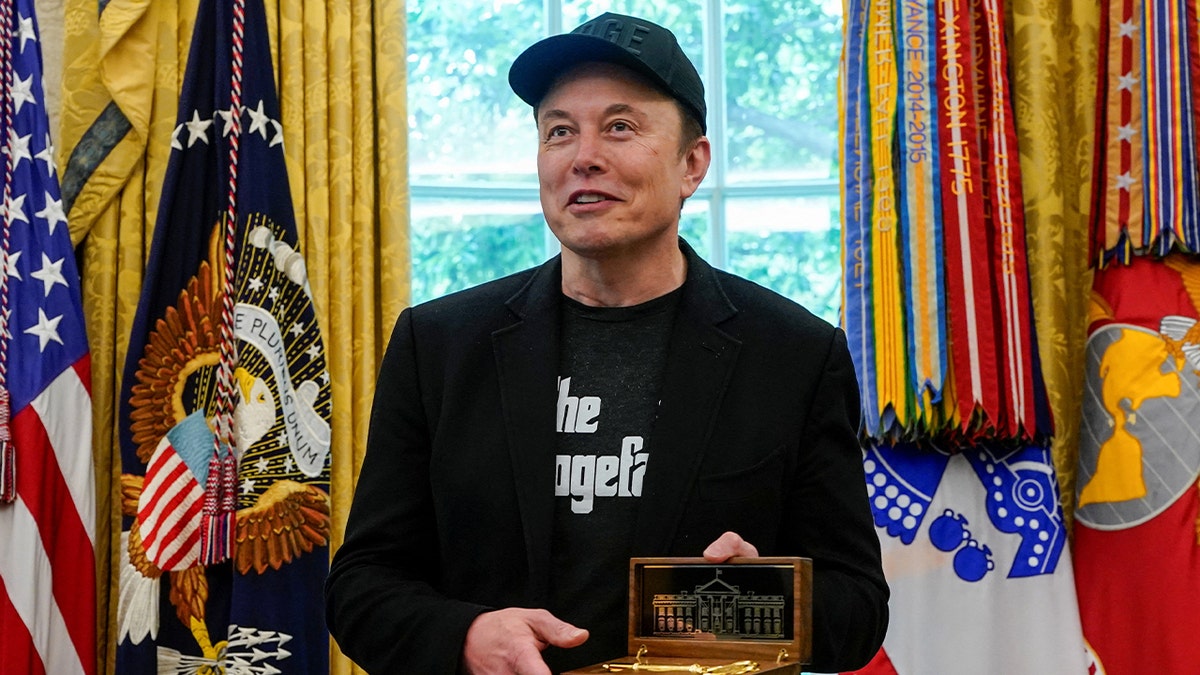 Elon Musk holds the "key to the White House" he received from President Donald Trump