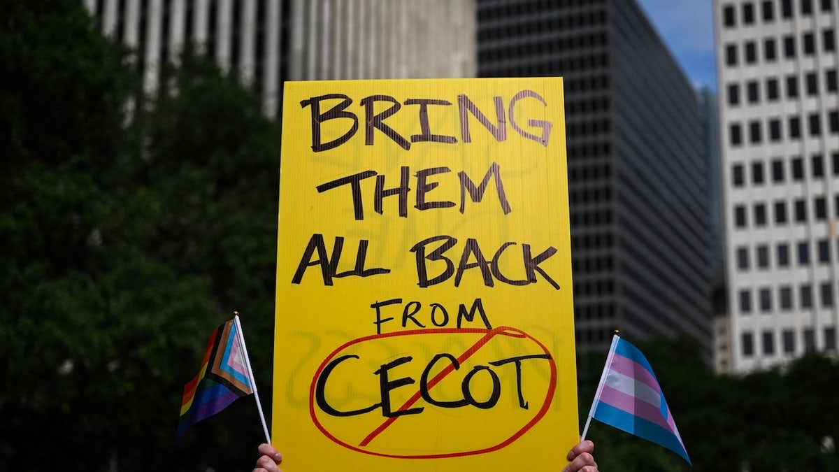 A person holds up a sign referencing the Centre for Terrorism Confinement prison in El Salvador during a May Day demonstration against President Donald Trump and his immigration policies in Houston on May 1, 2025.