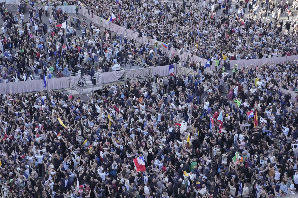 People watch as white smoke billows from the chimney of the Sistine Chapel where 133 cardinals are gathering on the second day of the conclave to elect a successor to late Pope Francis, at the Vatican, Thursday, May 8, 2025 