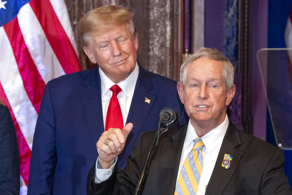 Former President Donald Trump, left, listens as Rep. Joe Wilson (R-SC) speaks at a campaign event at the South Carolina Statehouse, Saturday, Jan. 28, 2023, in Columbia, South Carolina. (AP Photo/Alex Brandon)