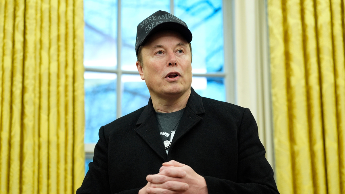 Elon Musk closeup shot, yellow curtains behind him