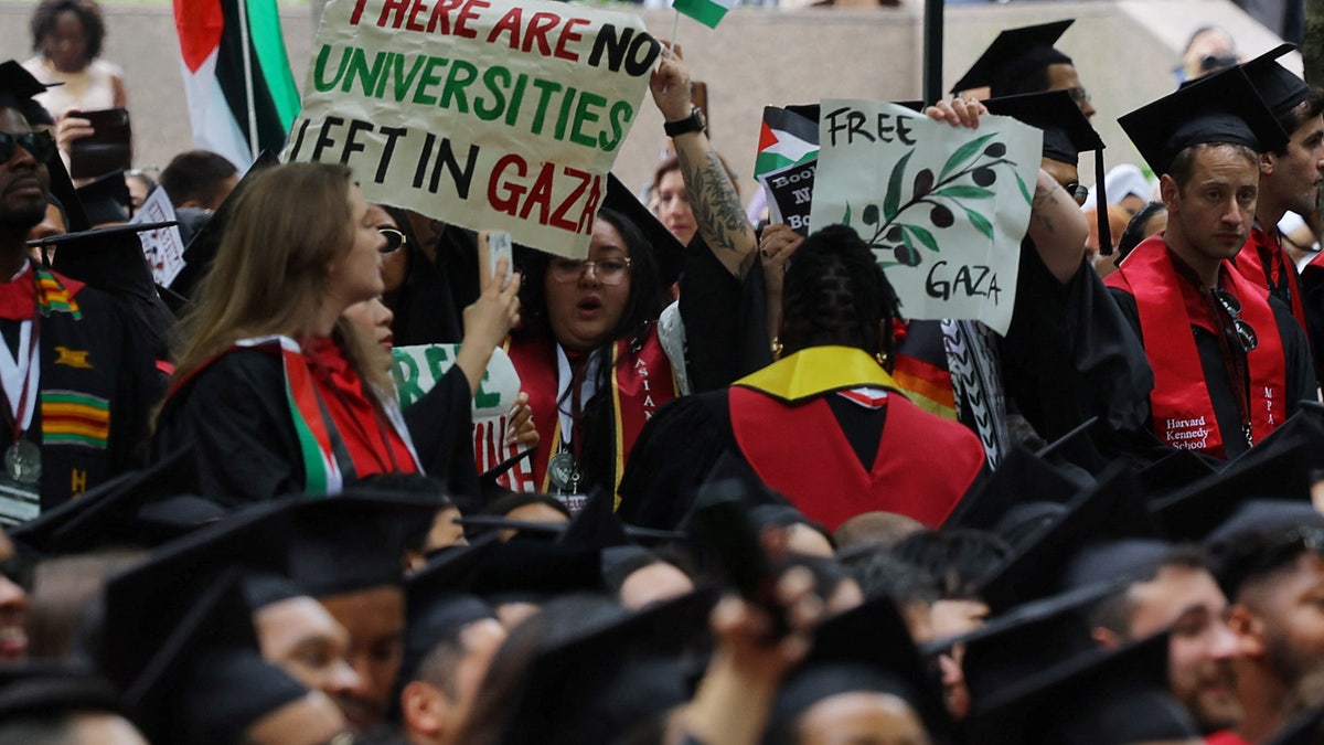 Graduating students hold a sign reading "There Are No Universities Left in Gaza" during the 373rd Commencement Exercises at Harvard University, amid the ongoing conflict between Israel and the Palestinian Islamist group Hamas, in Cambridge, Massachusetts, U.S., May 23, 2024. 