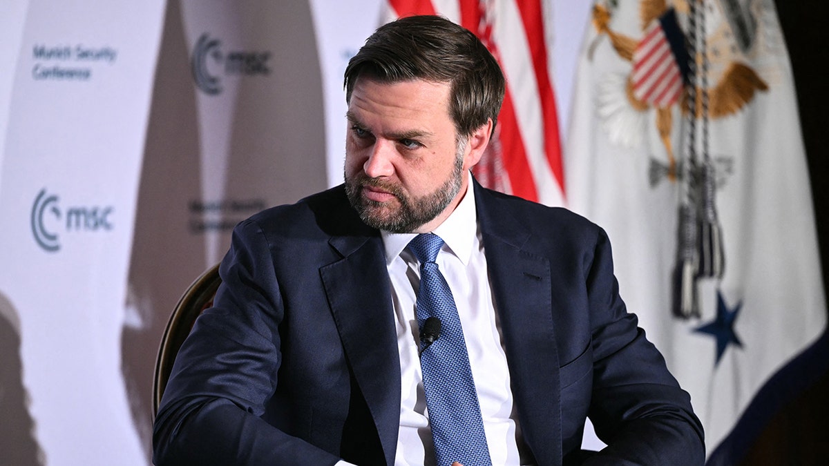 JD Vance looks serious on stage of DC Munich Security Conference event