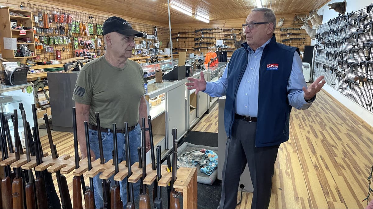 Former Maine Gov. Paul LePage, who's running a Republican campaign for Congress in 2026, speaks to a voter at a gun shop and indoor firing range, on May 7, 2025, in Poland, Maine.