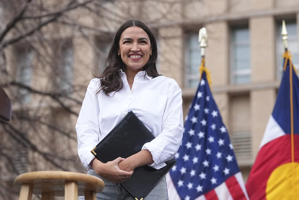 Rep. Alexandria Ocasio-Cortez, D-N.Y., smiles after speaking during a stop of their "Fighting Oligarchy" tour that filled Civic Center Park, Friday, March 21, 2025, in Denver.