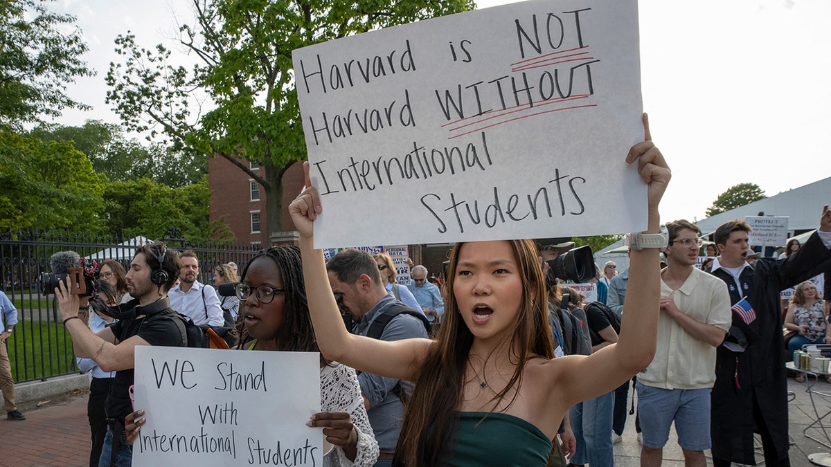 Harvard students hold protest signs in support of international students