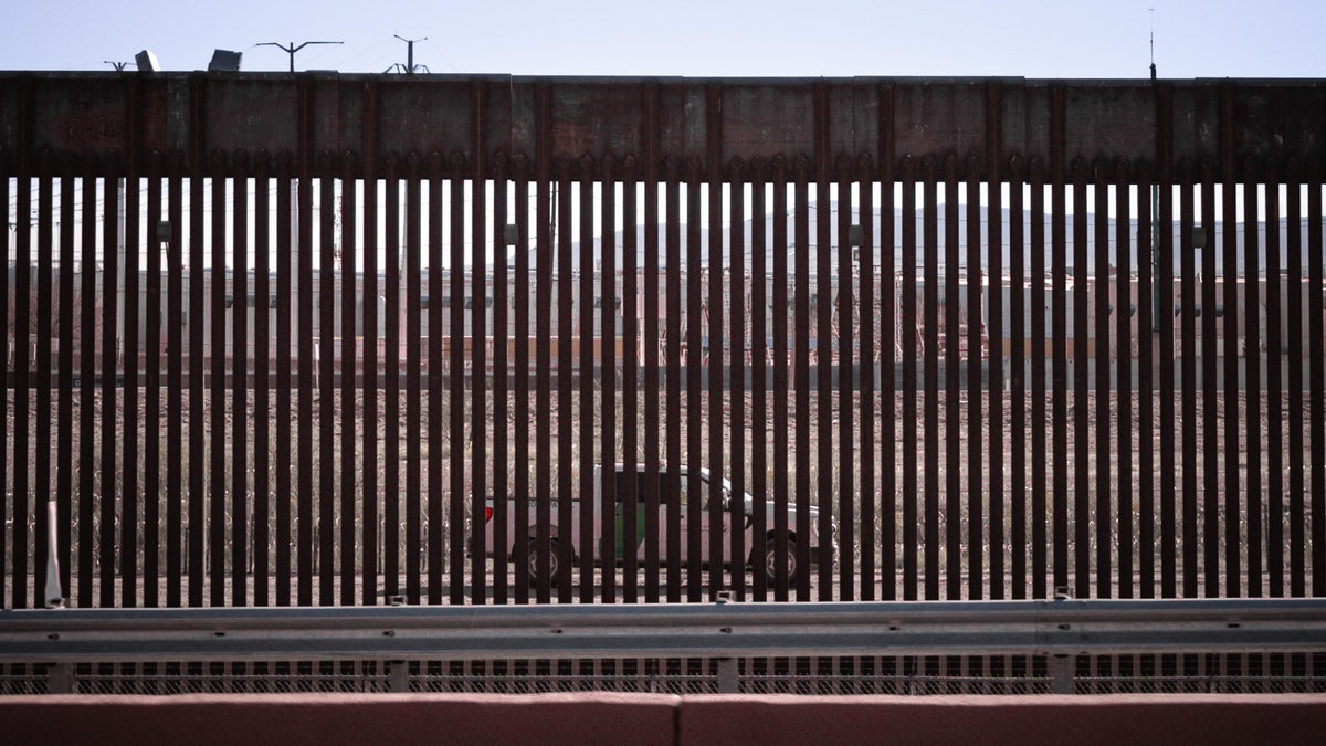 truck seen through border wall slats