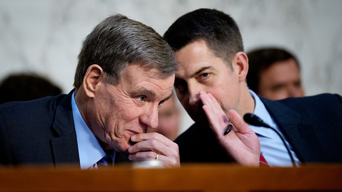 Sen. Mark Warner (D-VA) speaks with Sen. Tom Cotton