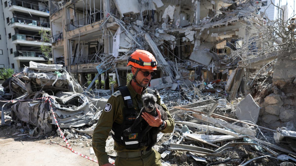 A rescue personnel holds Tess, a dog rescued from a building that was hit at an impact site following missile attack from Iran on Israel, in Ramat Gan, Israel, June 14, 2025.