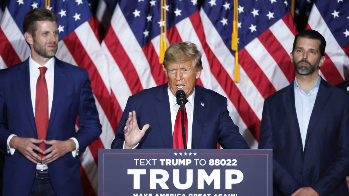 Trump at lectern, sons Eric and Don Jr flanking him