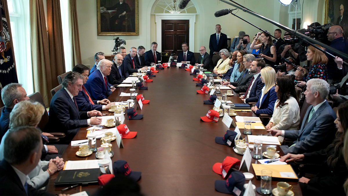 President Trump speaks during a Cabinet meeting at the White House, flanked by top officials and aides seated around a long table.