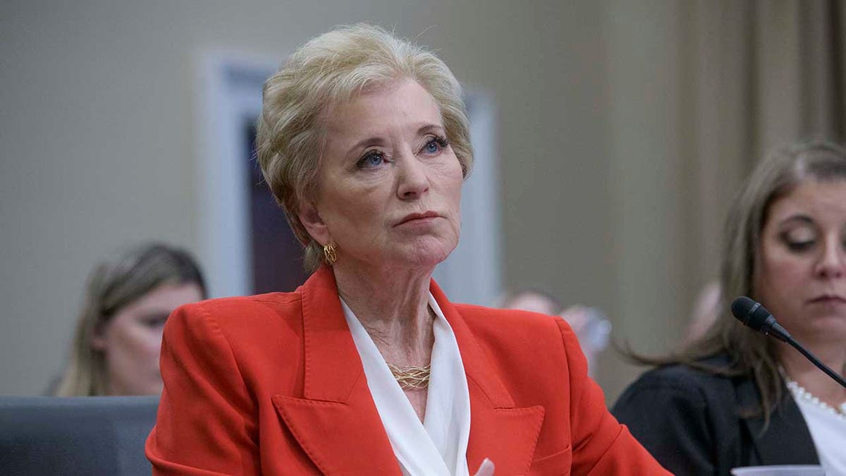 Linda McMahon looks on