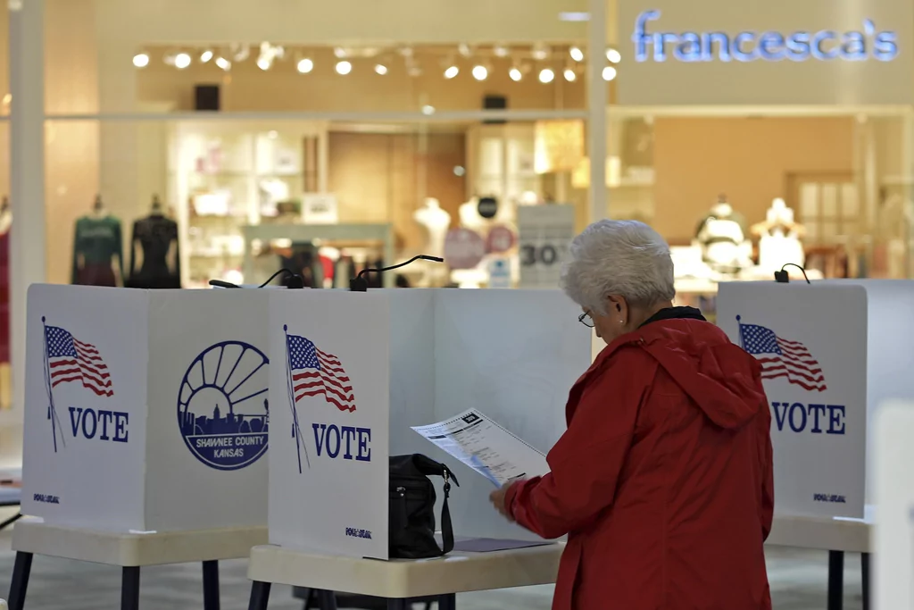 Delores Engel looks over her ballot while voting at the West Ridge Mall Tuesday, Nov. 5, 2024, in Topeka, Kansas. (AP Photo/Charlie Riedel)