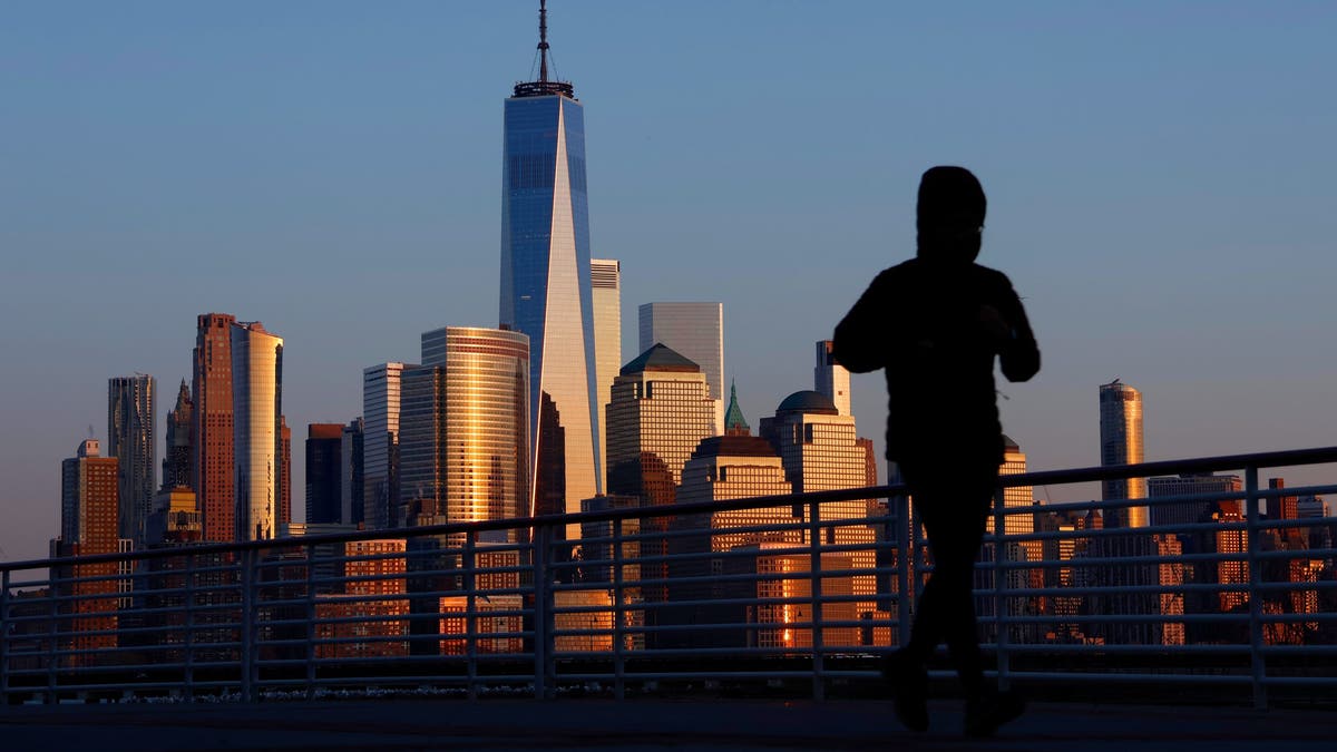 NYC skyline behind a jogger