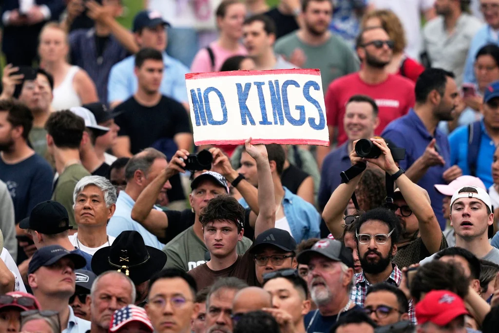 A person holds a sign reading 'No Kings' during a military parade commemorating the Army's 250th anniversary, coinciding with President Donald Trump's 79th birthday, Saturday, June 14, 2025, in Washington. (AP Photo/Julia Demaree Nikhinson)