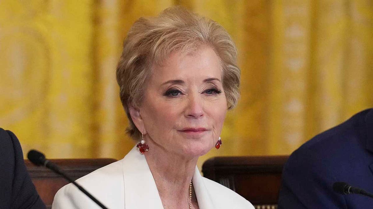 Linda McMahon looks on