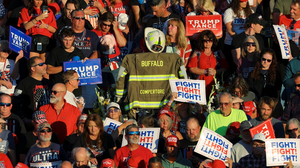 Corey Comperatore’s turnout coat is displayed in the crowd during a moment of silence at a Trump rally in Butler, Pa., honoring the slain volunteer fire chief.