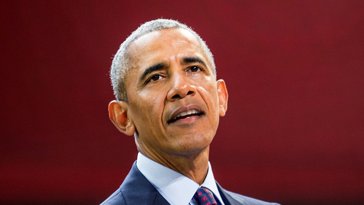 Former President Barack Obama in front of a red background