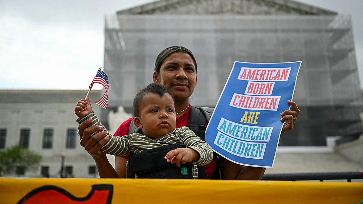 A woman is pictured protesting outside the U.S. Supreme Court building with her infant.