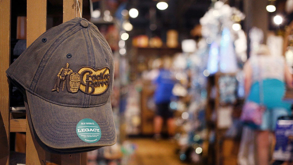 A hat displaying the old Cracker Barrel logo is on display inside a restaurant.