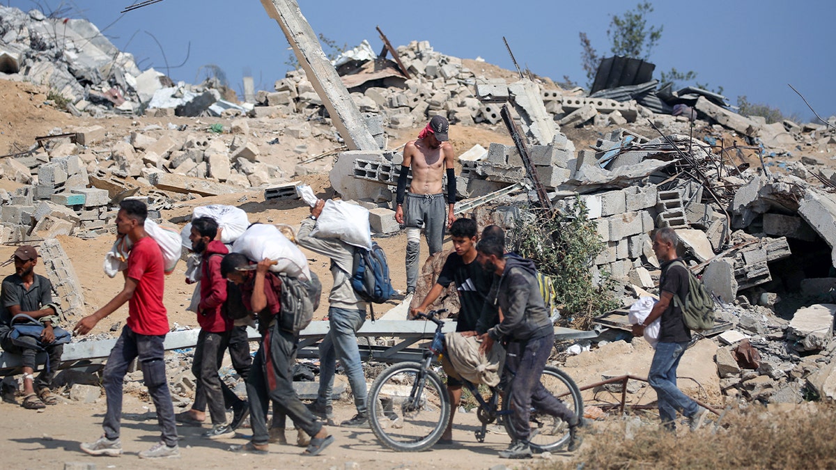 Palestinians in front of rubble
