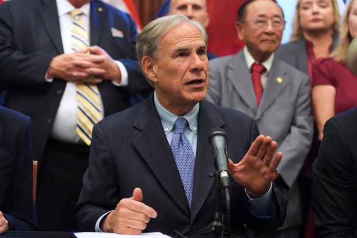 Texas Gov. Greg Abbott speaks to the media following a bill signing as Texas senators debate a bill on a redrawn U.S. congressional map during a special session in the Senate Chamber at the Texas Capitol in Austin, Texas, Friday, Aug. 22, 2025.