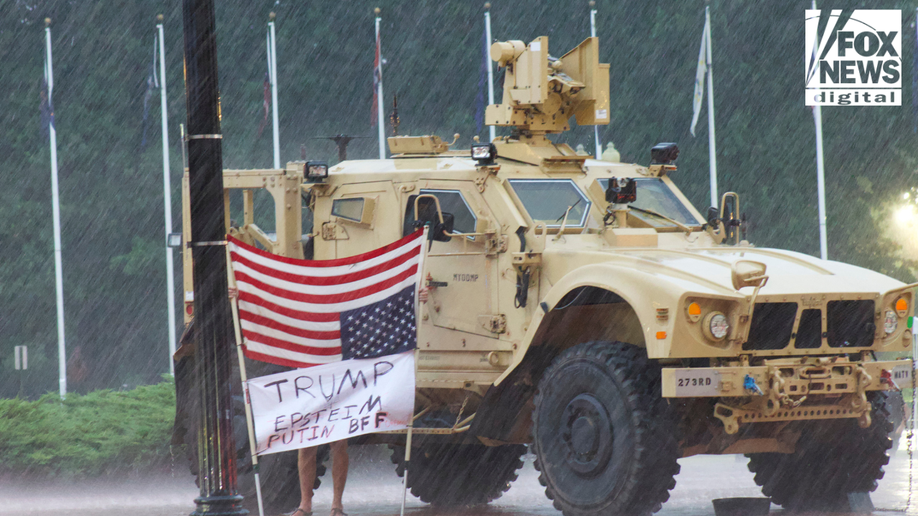 Protest stands in the rain to protest national guard