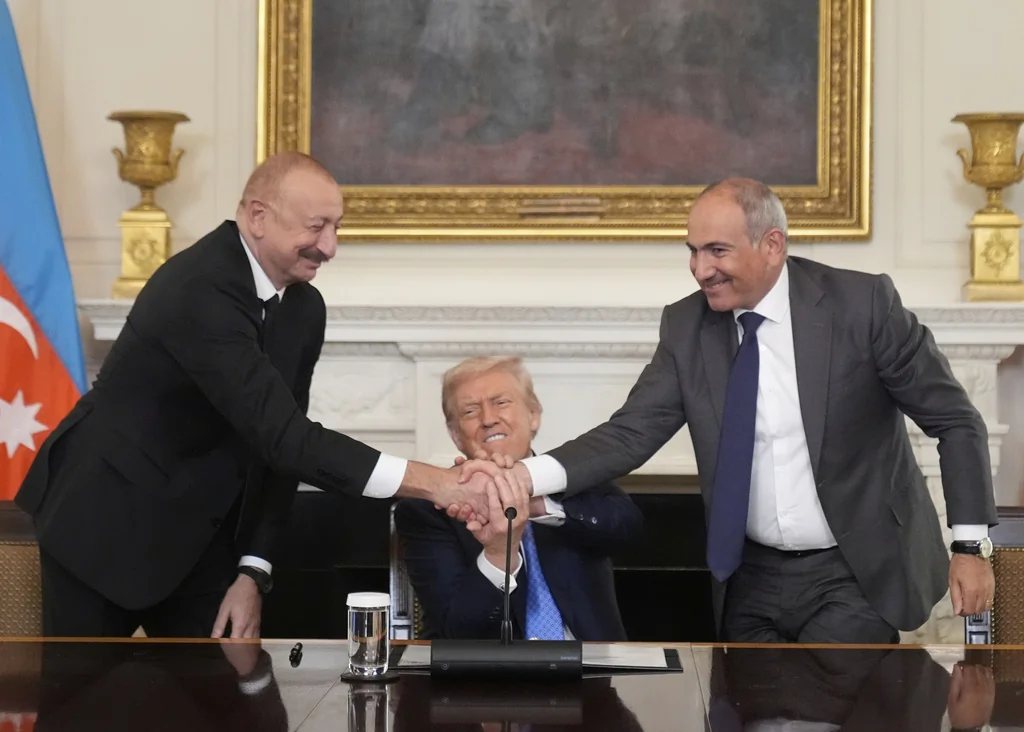 President Donald Trump, center, shakes hands with Armenian Prime Minister Nikol Pashinyan, right, and Azerbaijan President Ilham Aliyev during a trilateral signing ceremony in the State Dining Room of the White House, Friday, Aug. 8, 2025, in Washington. (AP Photo/Mark Schiefelbein)