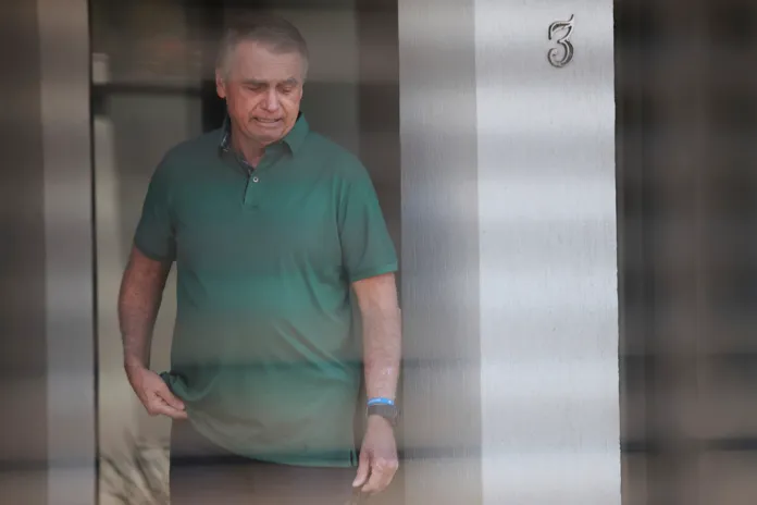 Brazil's former President Jair Bolsonaro stands at the entrance of his home where he is under house arrest in Brasilia, Brazil, Thursday, Sept. 11, 2025.