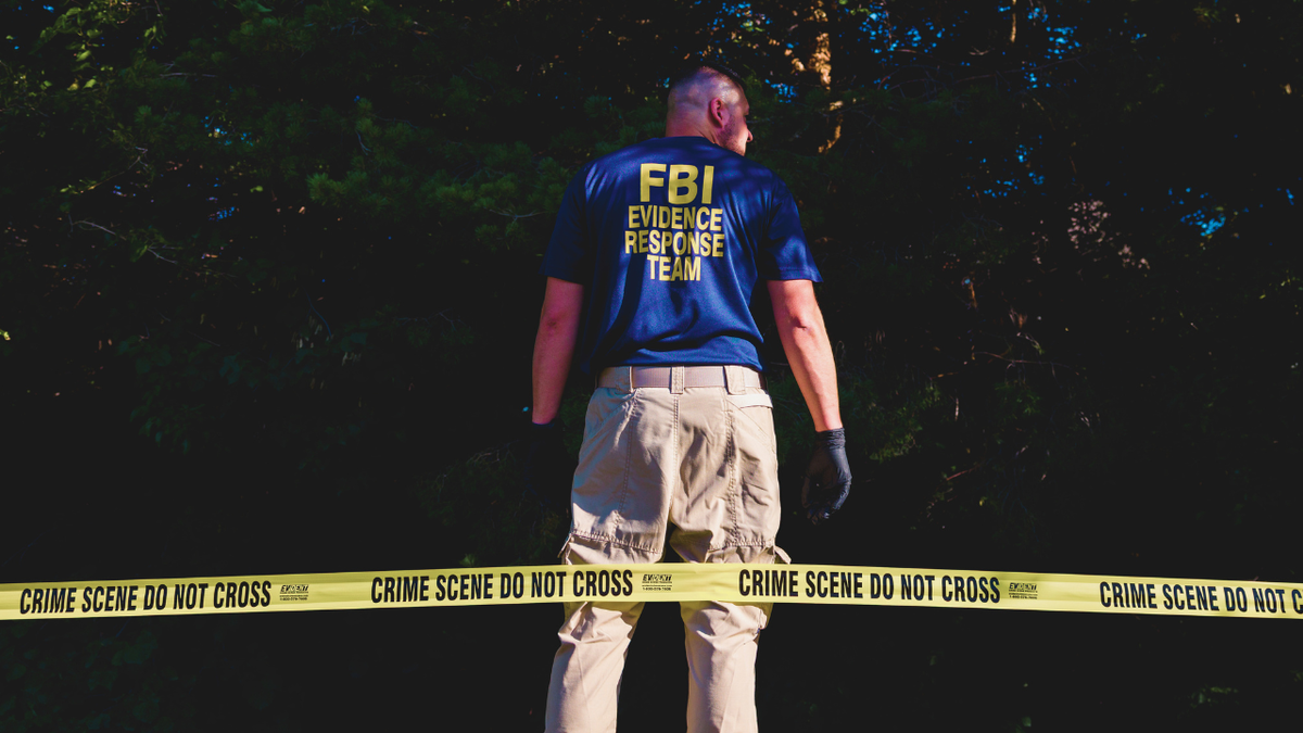 An FBI agent looks for evidence near Utah Valley University where Charlie Kirk was assassinated