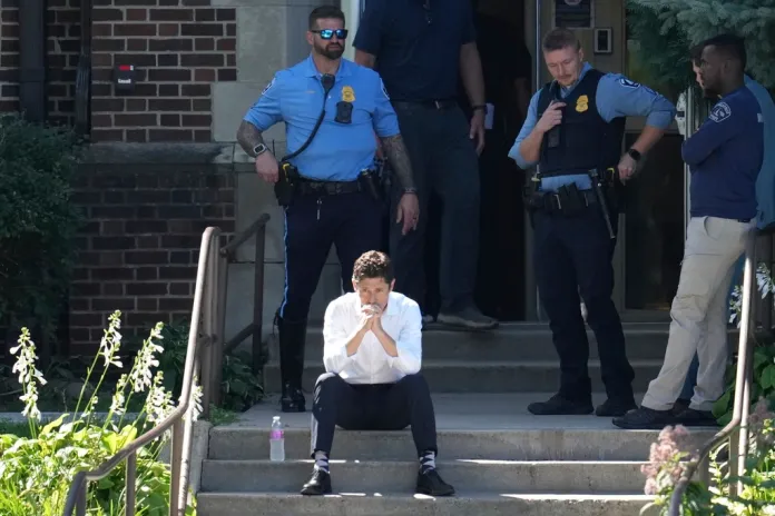 Minneapolis Mayor Jacob Frey sits on steps of the Annunciation Church's school as police respond to a reported mass shooting, Wednesday, Aug. 27, 2025, in Minneapolis. (AP Photo/Abbie Parr)