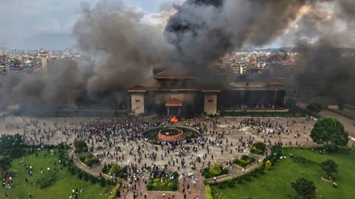 Protesters celebrate at the parliament building after it was set on fire during a protest against social media ban and corruption in Kathmandu, Nepal, Tuesday, Sept. 9, 2025.