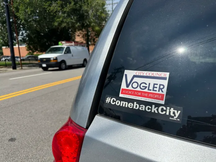 A bumper sticker for Lee Vogler is seen on the back of a car.