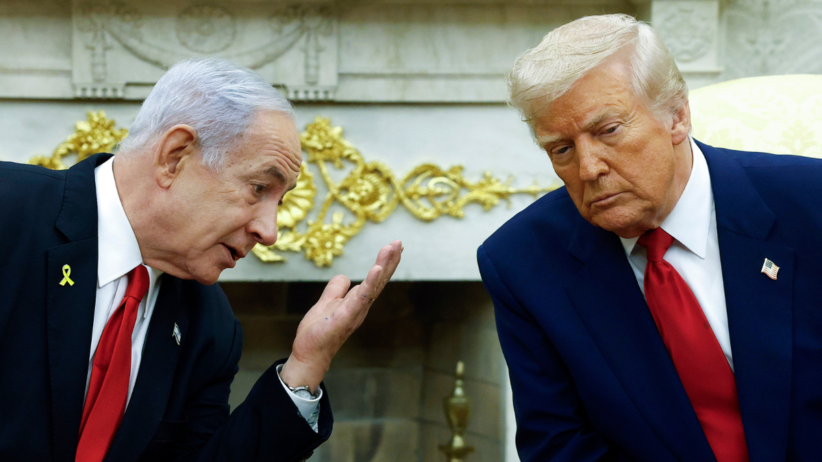 Israeli Prime Minister Benjamin talks to U.S. President Donald Trump during a meeting in the Oval Office