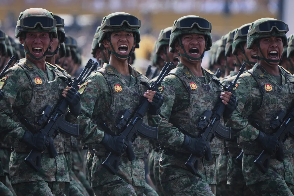 Military personnel shout as they take part in a military parade.
