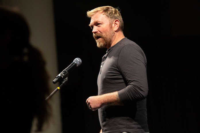 Progressive Maine Senate candidate Graham Platner speaks into a microphone.