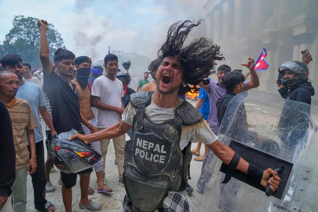 A protester wearing a flak jacket and carrying a shield snatched from a policeman shouts.