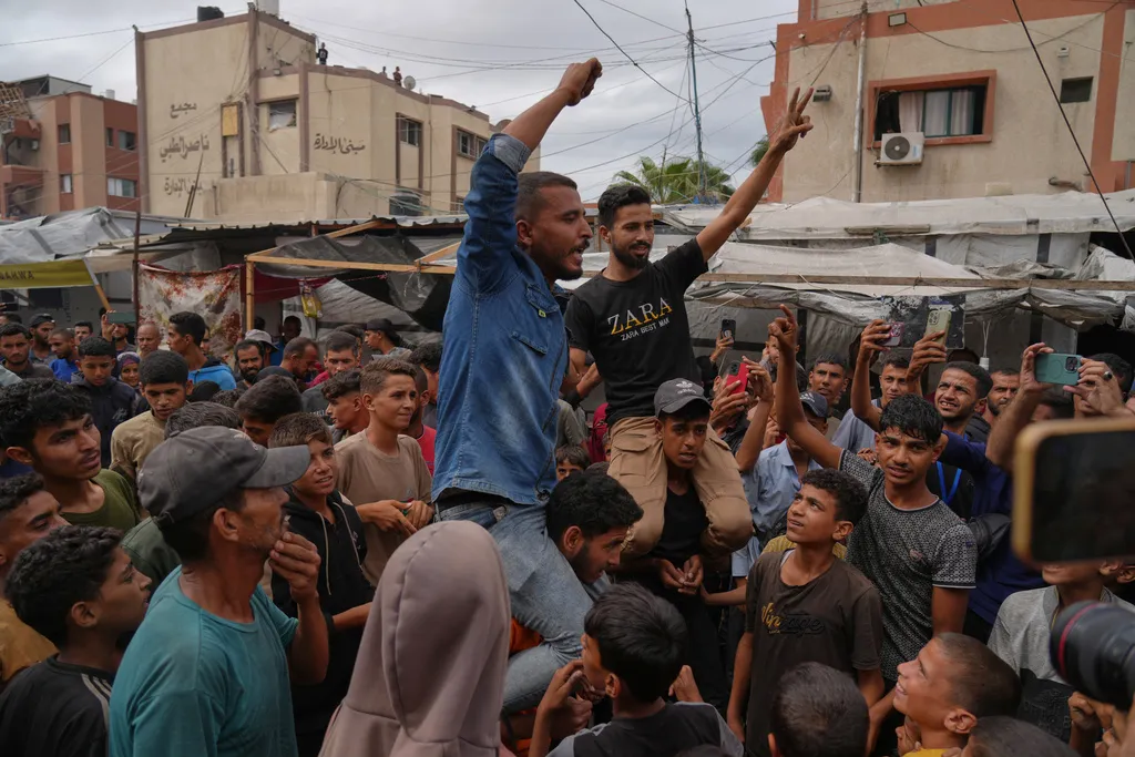 Palestinians celebrate following the announcement that Israel and Hamas have agreed to the first phase of a peace plan.