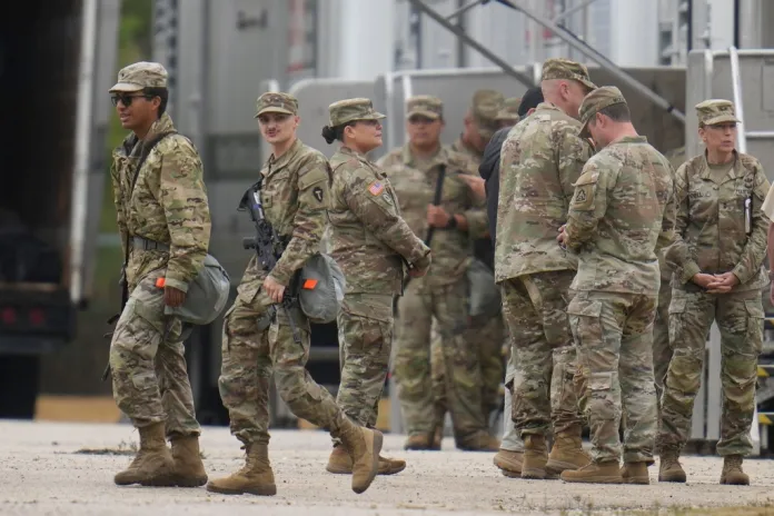 Military personnel in uniform, with the Texas National Guard patch on, are seen at the U.S. Army Reserve Center, Tuesday, Oct. 7, 2025, in Elwood, Ill., a suburb of Chicago. (AP Photo/Erin Hooley)