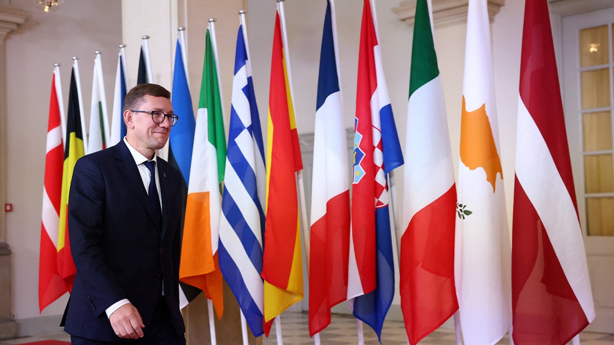 Estonia's Prime Minister Kristen Michal walks by flags in Denmark