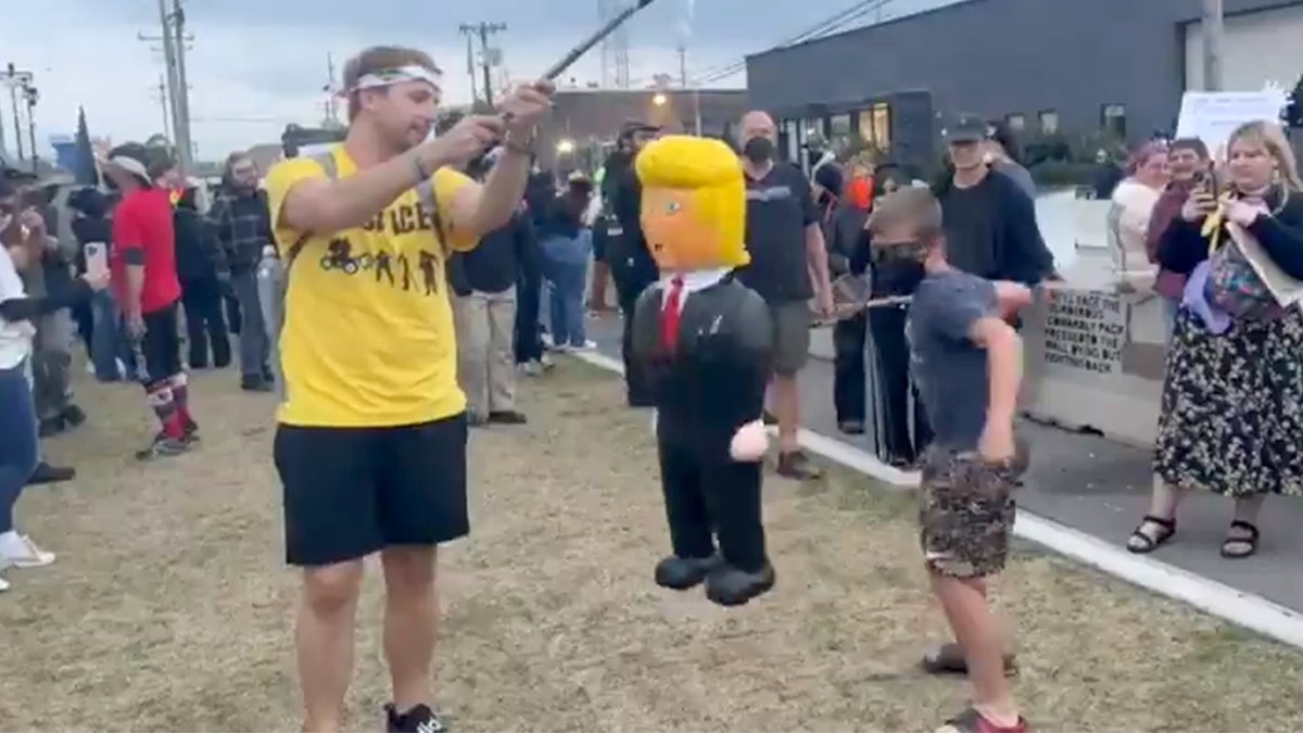 Protesters bash a Trump pinata
