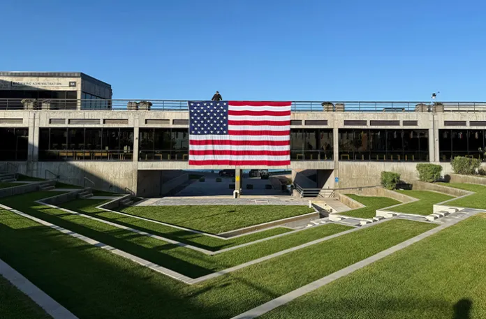 A national flag hangs over the site where conservative activist Charlie Kirk was shot and killed at Utah Valley University last week on Sept. 17, 2025, in Orem, Utah. (Jesse Bedayn/AP)
